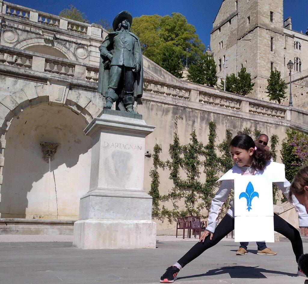 Enfant déguisée en mousquetaire, jouant sur l'escalier monumental à Auch